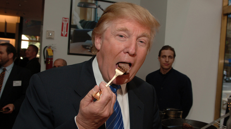 Donald Trump eating steak in a suit