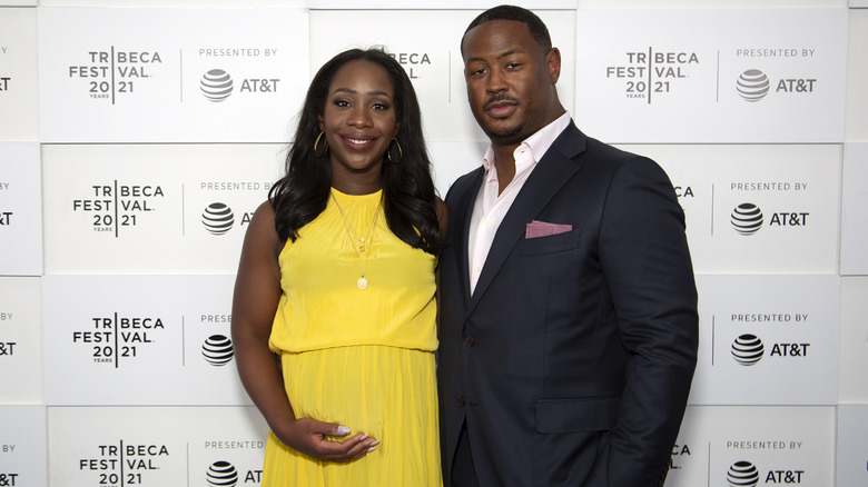 Abby Phillip in a yellow sleeveless dress standing next to husband Marcus Richardson in a suit