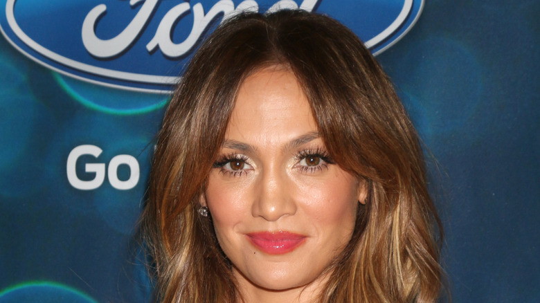 Jennifer Lopez smirking while wearing red lipstick.