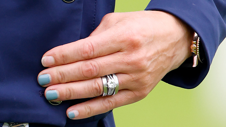 Zara Tindall's hand with rings and chipped blue nail polish