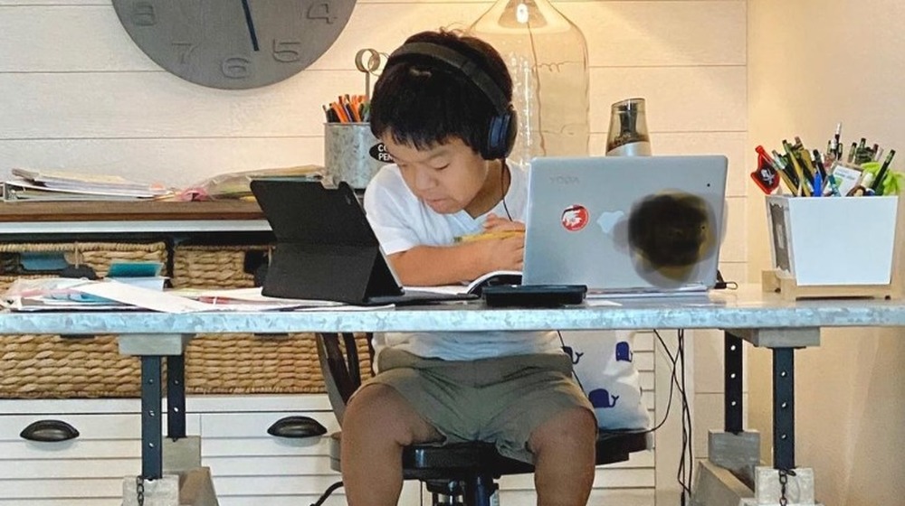 The Little Couple's son at a desk