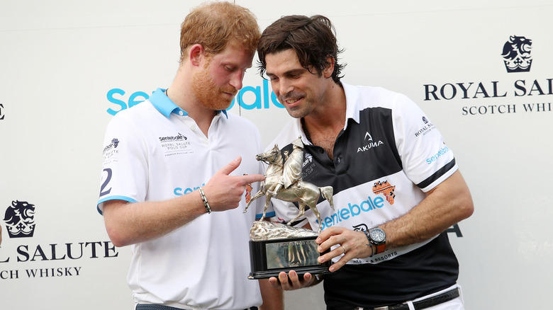 Prince Harry and Nacho Figueras looking at trophy