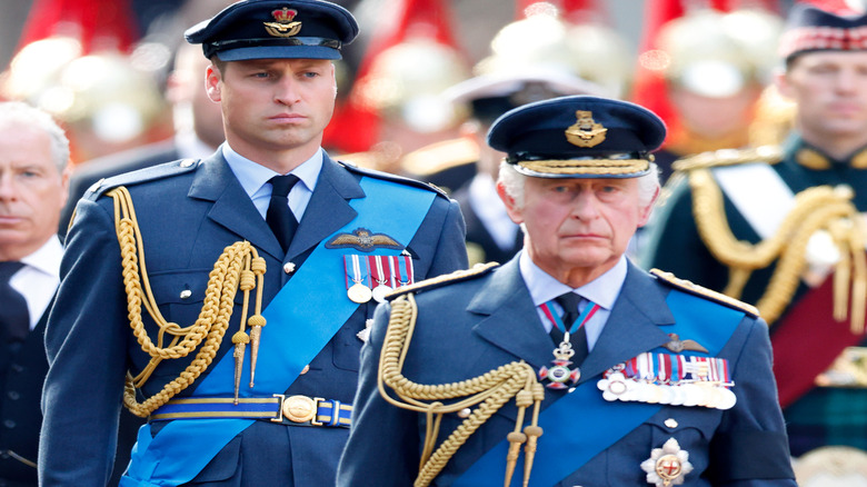 Prince William walking behind King Charles