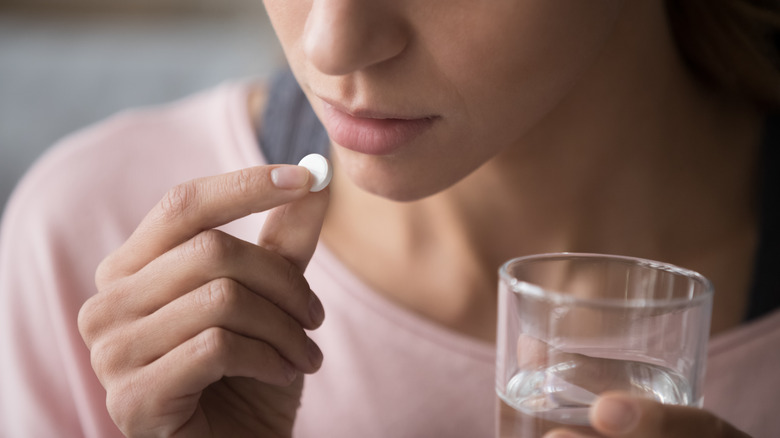 Woman preparing to take a pill