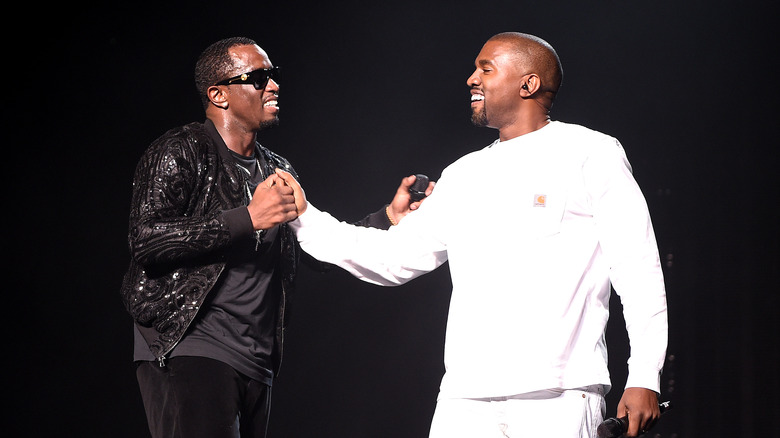 Diddy and Kanye West smiling at each other