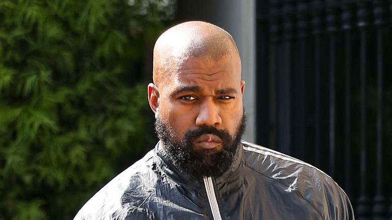 Kanye West frowning with a beard.