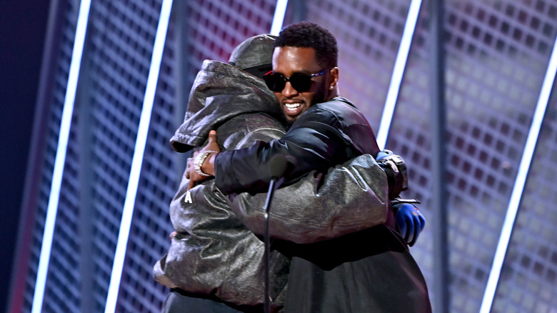 Kanye West and Diddy embracing on stage.