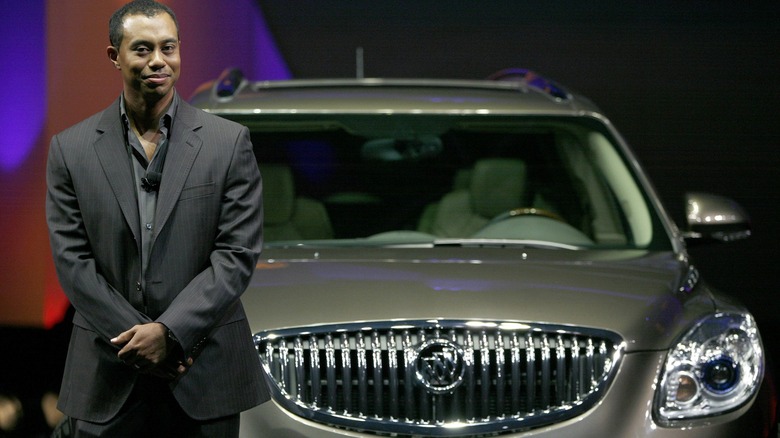 Tiger Woods posing with a Buick