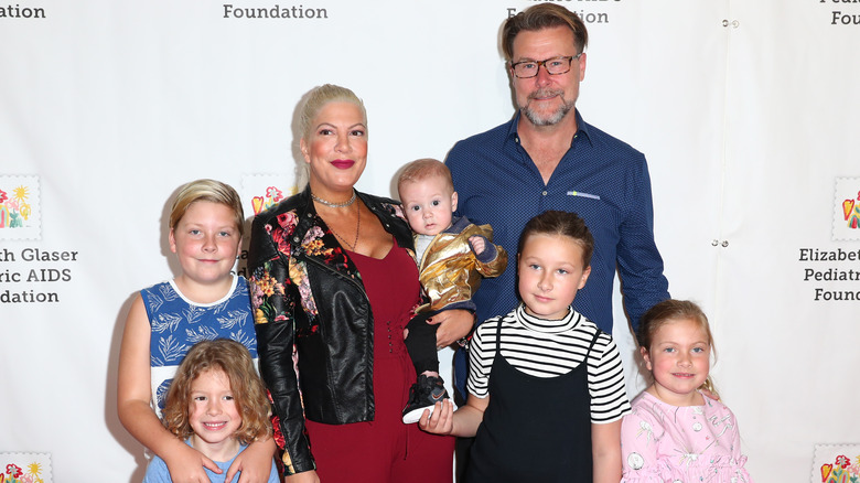 Dean McDermott and Tori Spelling smiling with their children