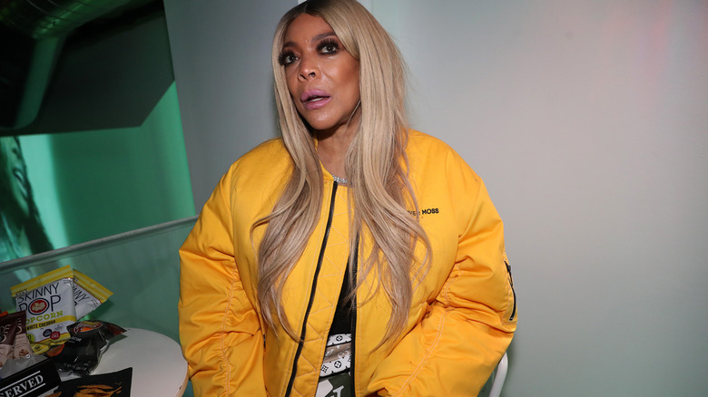 Wendy Williams posing for photos in a yellow jacket