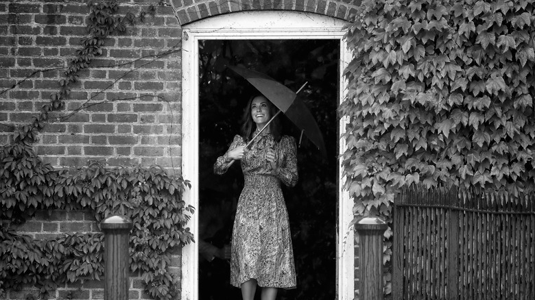 Kate Middleton holding umbrella at door
