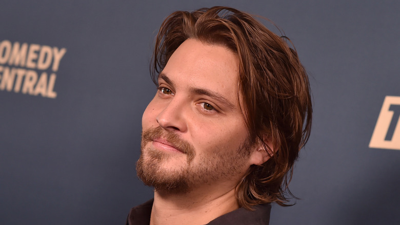 Luke Grimes smiling on red carpet