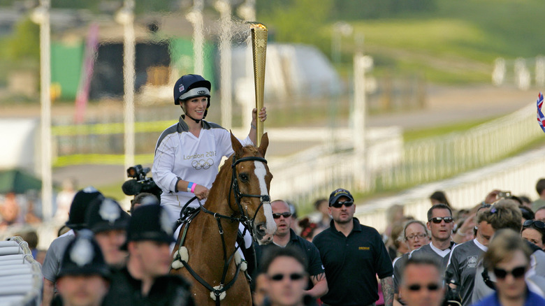 Zara Tindall carrying the Olympic torch on horseback