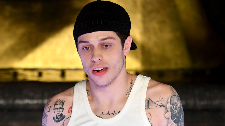 Pete Davidson wearing backward cap on the runway