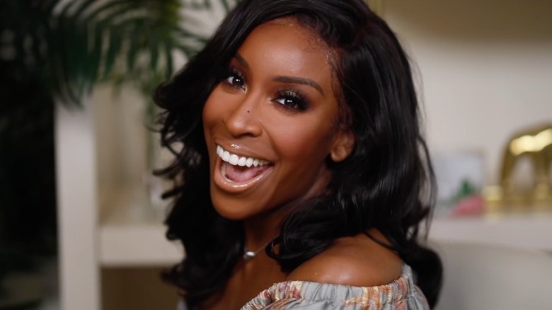 Jackie Aina smiling in full makeup