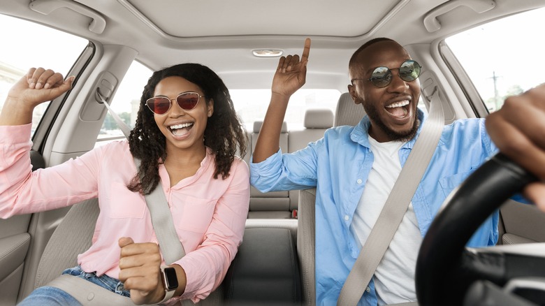 A couple dancing in a car 