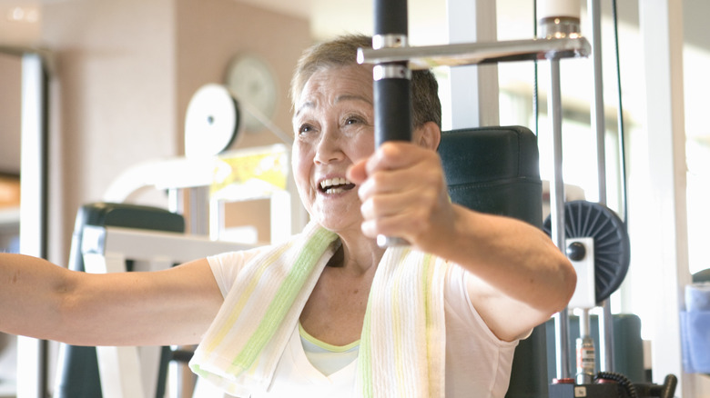 Older woman using gym machine 