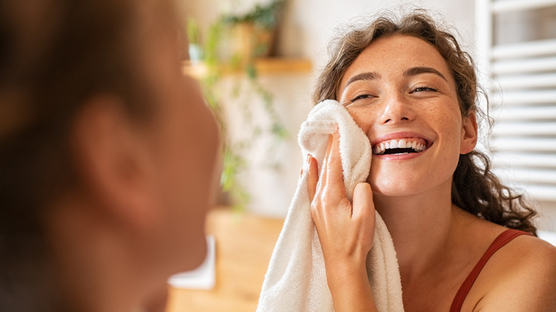 Woman smiling as she pats face dry