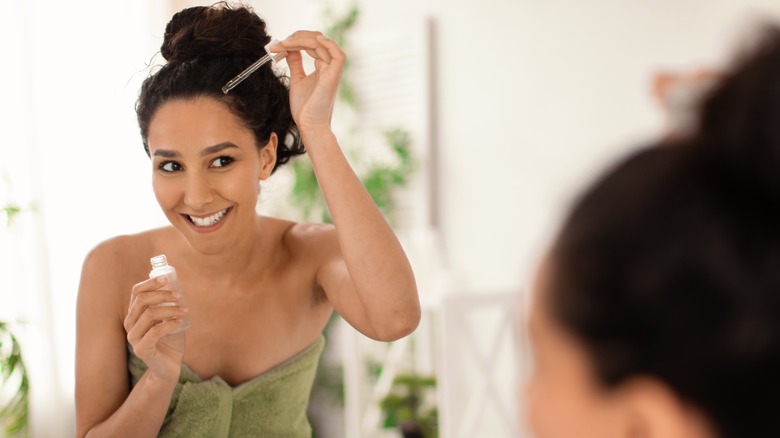 woman applying oil to scalp