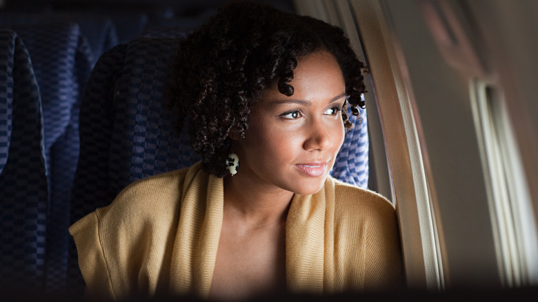 woman looking out plane window