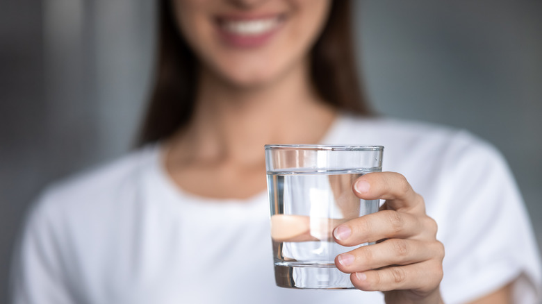 Woman holding glass of water