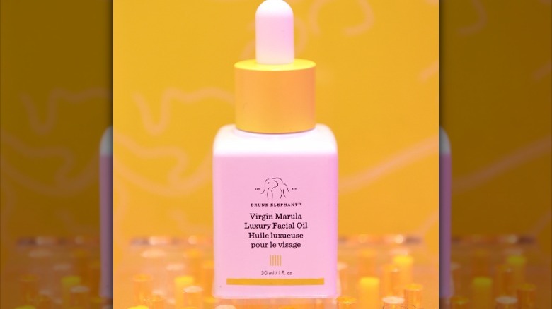 Drunk Elephant facial oil against a yellow backdrop