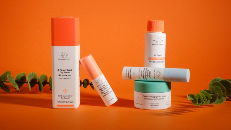 Drunk Elephant beauty products against an orange background