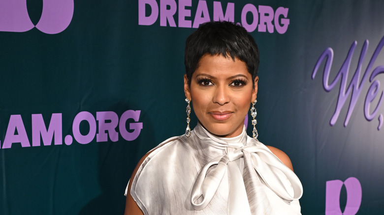 Tamron Hall silver dress in front of black and purple background