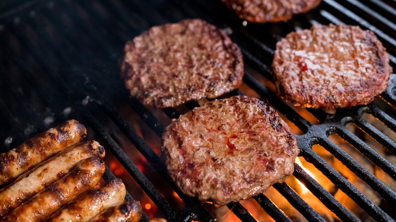 Burger and sausages on grill 