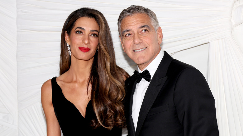 Amal and George Clooney smiling in evening wear