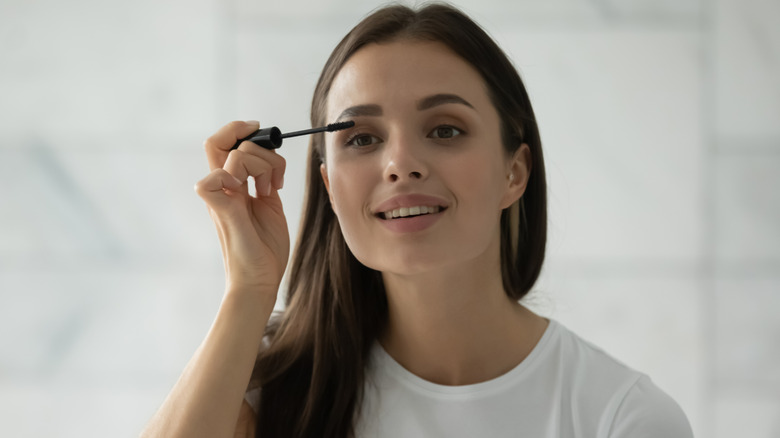 Woman putting on mascara 