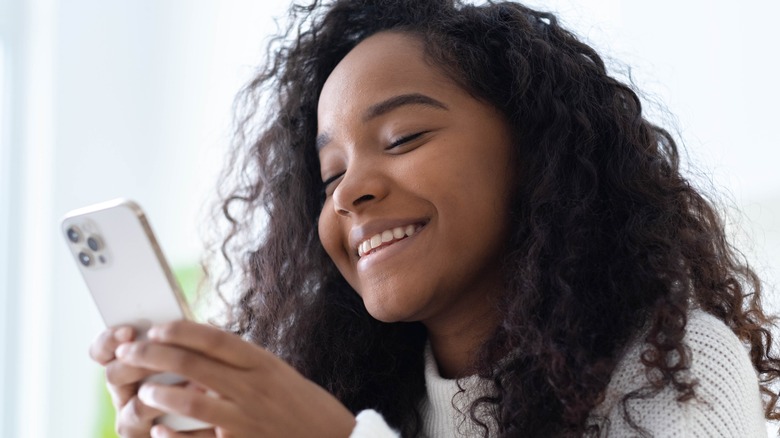 Young girl texting and laughing