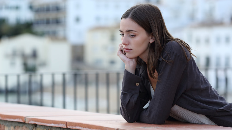 woman looking down longingly