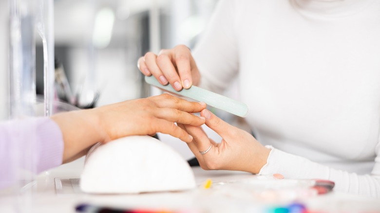 Woman getting her nails buffed