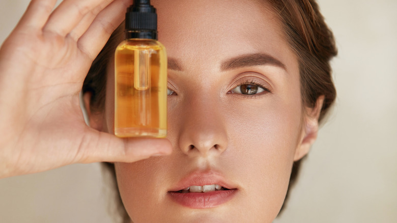 woman holding dropper bottle