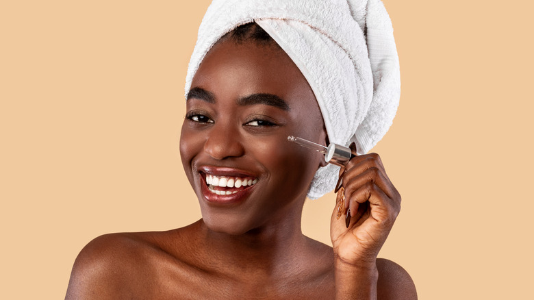 woman holding a bottle of skin serum