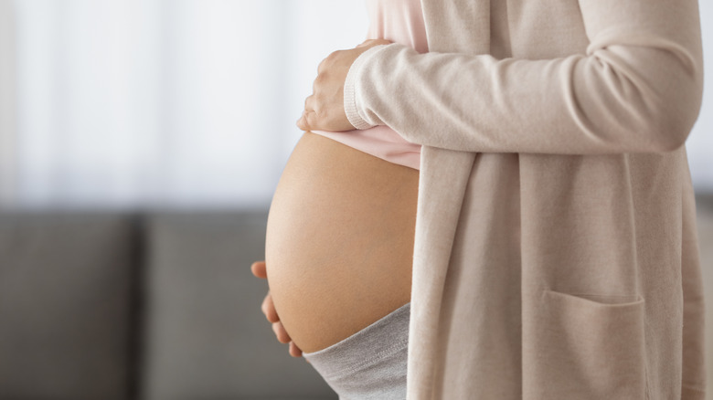 Pregnant woman showing belly