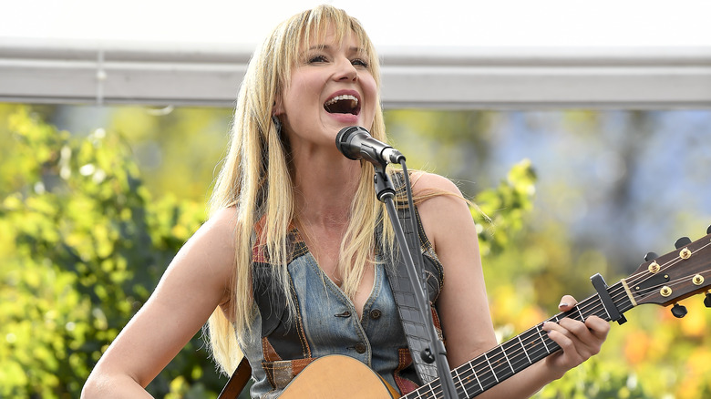 Jewel singing with guitar outdoors