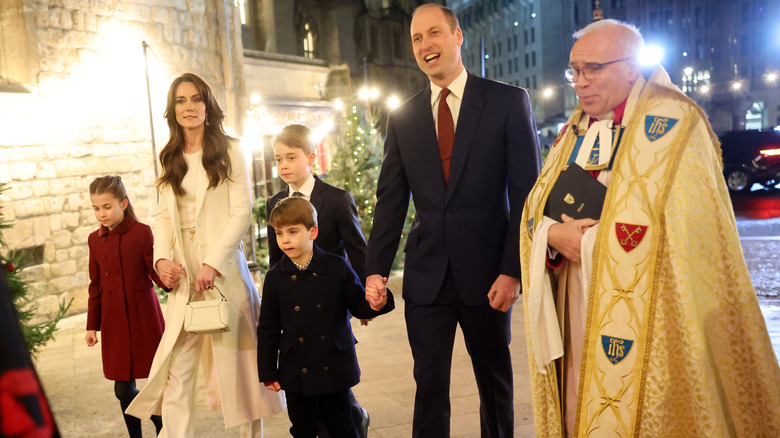 Prince William and Kate Middleton walking with their kids and a priest at Christmas