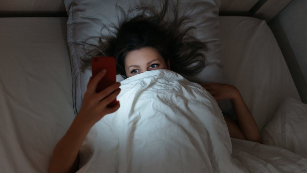 woman in bed on smartphone