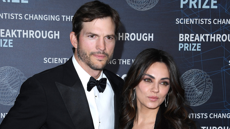 Ashton Kutcher posing with Mila Kunis