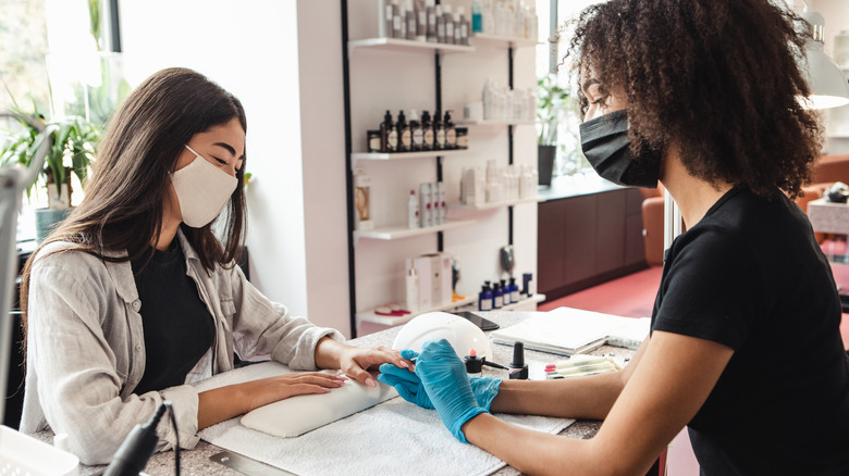 Women in masks getting a manicure