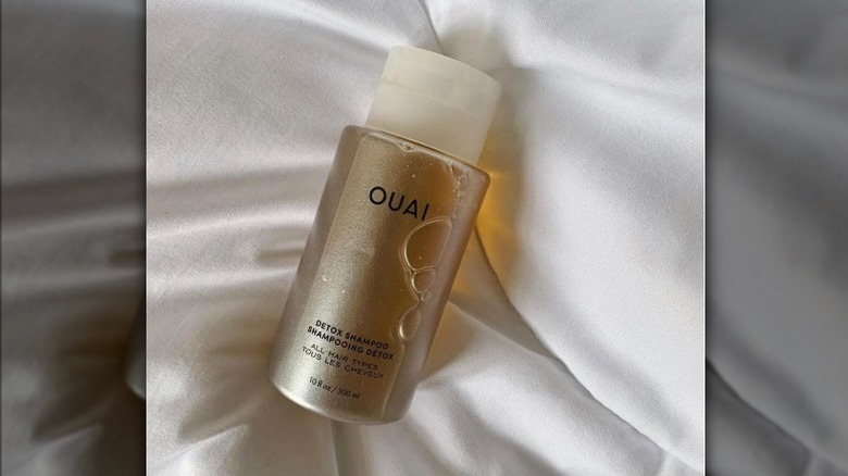 Ouai Detox Shampoo on bed 