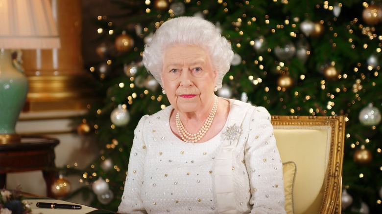 Queen Elizabeth II in front of a Christmas tree