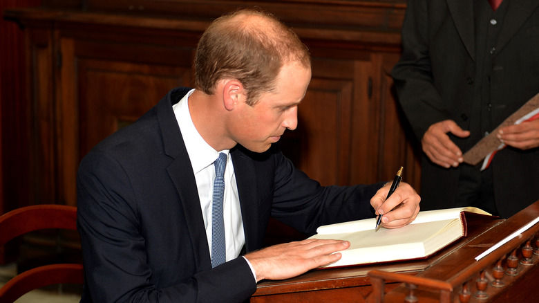 Prince William signing a book