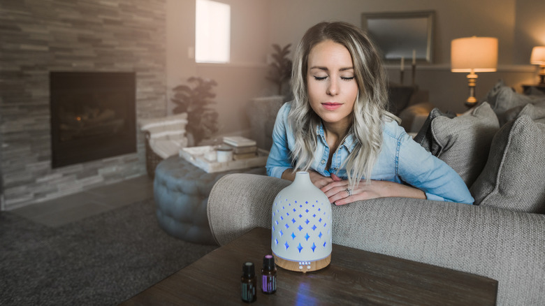 Woman inhaling the fragrance coming from a diffuser