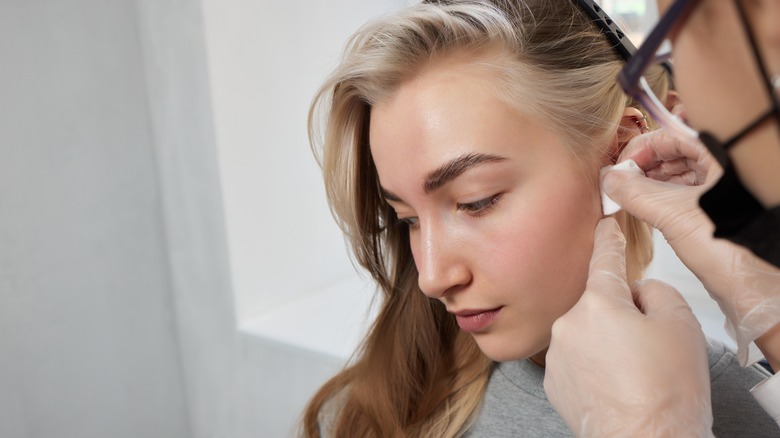 Woman getting ear piercing