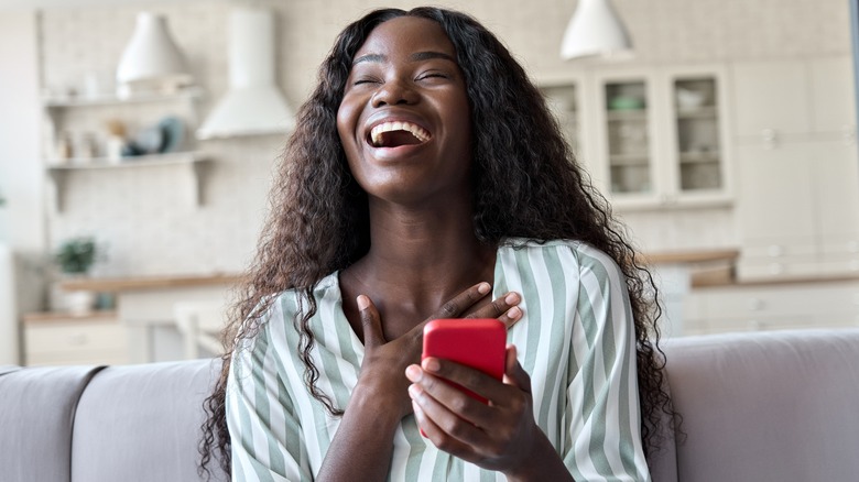 Woman laughing at her phone