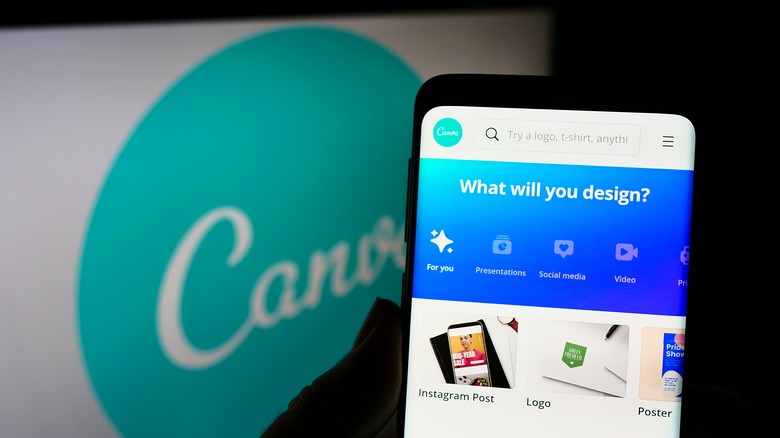 Open Canva app on smart phone in front of a monitor showing Canva logo