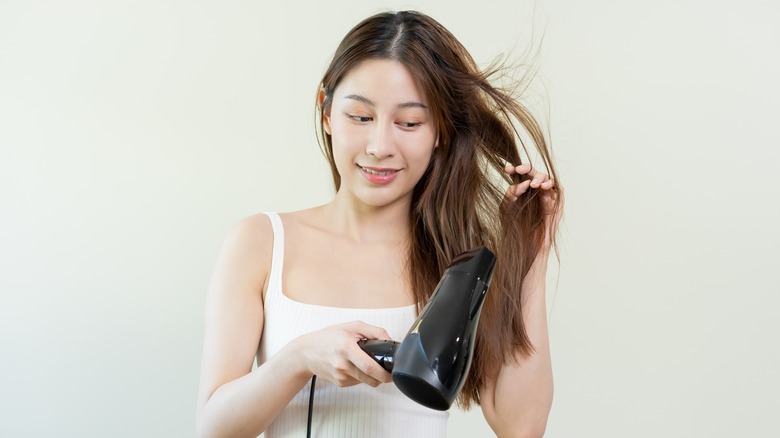 Woman smiling while drying hair